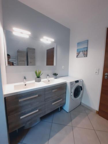 a bathroom with two sinks and a washing machine at Charmante demeure au cœur de la provence verte in Bras