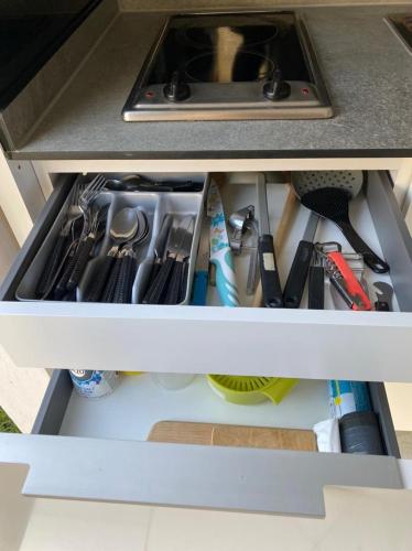 a drawer in a kitchen counter with tools in it at Résidence La Baie 1 Océane in La Trinité