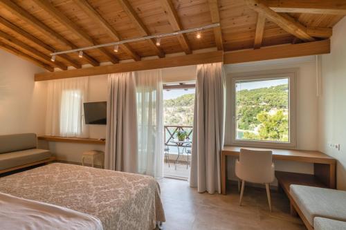 a bedroom with a bed and a desk and a window at Liadromia Hotel in Patitiri