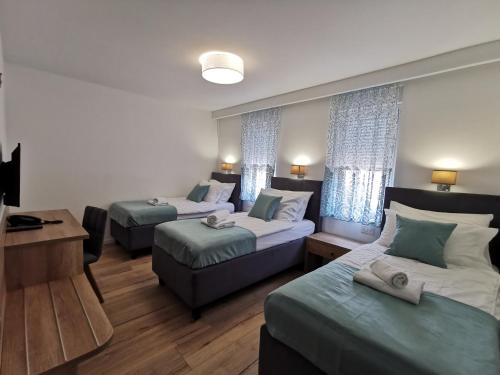 a hotel room with two beds and a desk and a room at Hotel Soldo in Međugorje