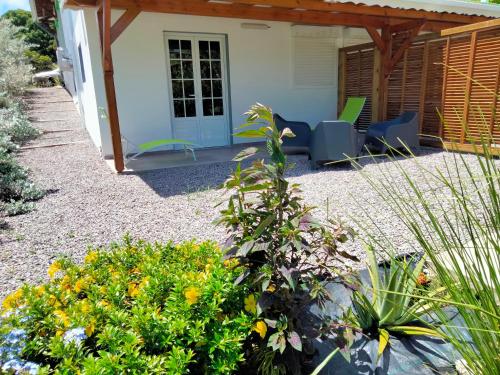 a patio with chairs and flowers in front of a house at LES GÎTES DE BIBINE gîtes tout confort coin calme et tranquille in Rabi