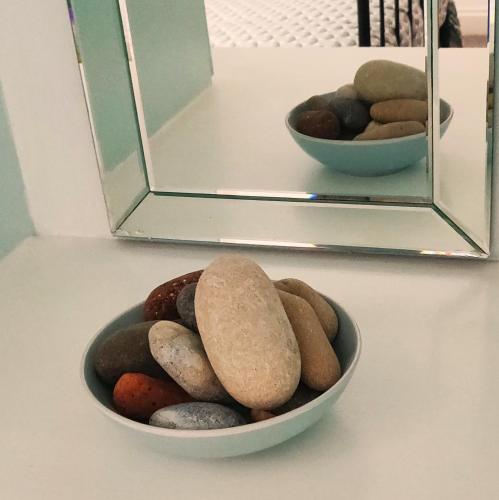a bowl of rocks sitting in front of a mirror at Leylands - Perfect location near town and beach in Cromer