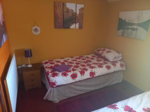 a bedroom with a bed with a flowery bedspread at Yarm cottages the rafters in Kirk Leavington