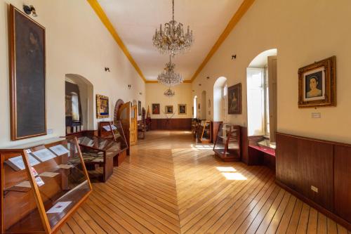 a large room with wooden floors and a chandelier at Friends Hotel & Rooftop - Historic Center & Museums in Quito