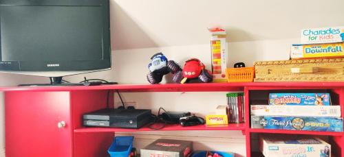 a red shelf with a tv on top of it at Leylands - Perfect location near town and beach in Cromer