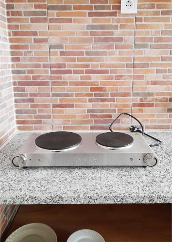 a stove top with two burners on a brick wall at Casa Terra Cota - Almada in Almada