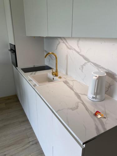 a white kitchen counter with a sink and a cup at Mano jūra 2 apartamentai in Palanga
