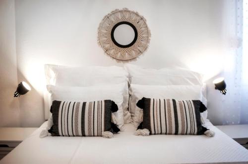 a white bed with white pillows and a mirror at bed&breakfast Bohemian in Rovinj