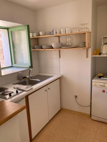 una pequeña cocina con fregadero y ventana en Gîte Communal des Remparts, en Le Val