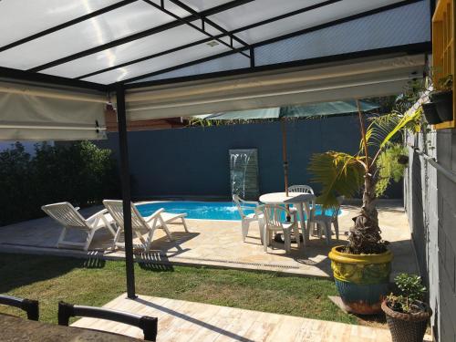 a patio with a table and chairs and a pool at recanto palmeira imperial Holambra SP in Holambra