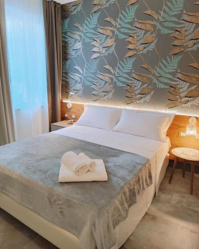 una camera da letto con un letto e un asciugamano sopra di Le stanze di Diana a Cesenatico