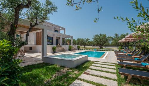 a villa with a swimming pool and lounge chairs at Delight Luxury Villa - Contemporary Elegance & Tranquility, by ZanteWize in Zakynthos Town