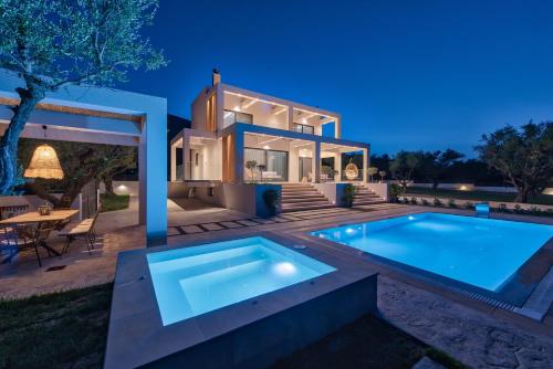 a villa with a swimming pool in front of a house at Delight Luxury Villa in Zakynthos Town