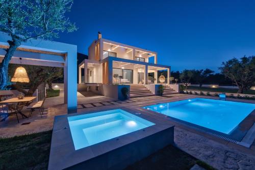 a villa with a swimming pool in front of a house at Delight Luxury Villa - Contemporary Elegance & Tranquility, by ZanteWize in Zakynthos Town