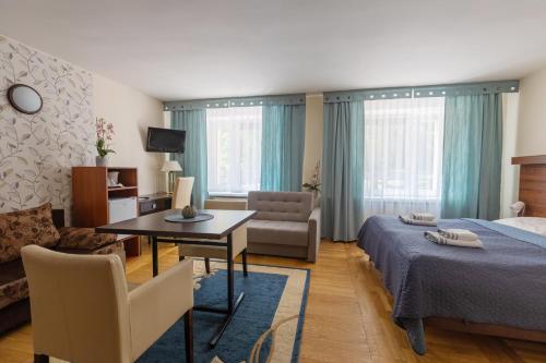 1 dormitorio con cama, mesa y sofá en Sadyba SPA, en Karpacz