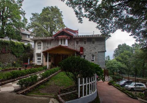 a house with a fence in front of it at The Hilltop Haven in Nainital