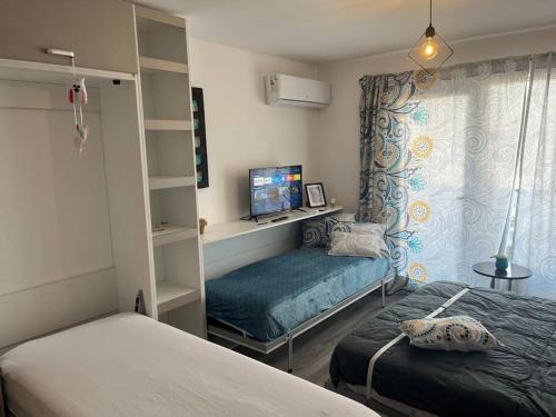 a small bedroom with two beds and a window at Studio en Puerto Norte 4 personas p3 in Rosario