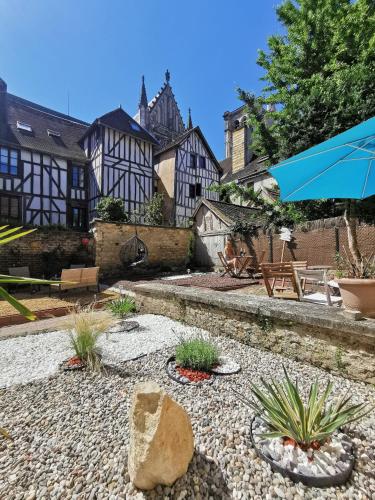 a patio with an umbrella and some plants at Le Papillon de la Cathédrale - Calme - Jardin - Wifi in Troyes