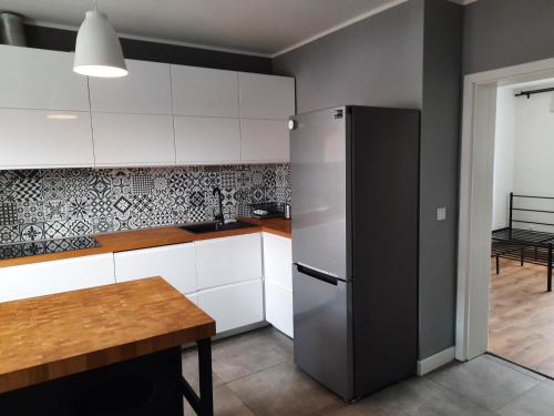 a kitchen with a refrigerator and a table in it at Apartament Janickiego in Szczecin