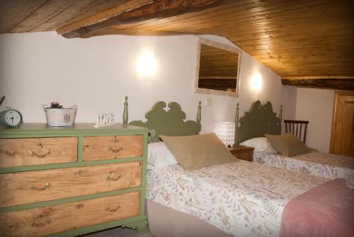 a bedroom with two twin beds and a dresser at LA CASITA DEL PORTAL in Pedro Bernardo