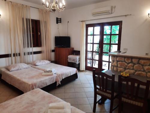 a hotel room with two beds and a table and chairs at Apartments Zlosilo in Orasac