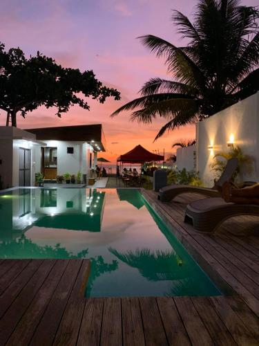 a pool in a villa with a sunset in the background at RLJ Beach House in Naval
