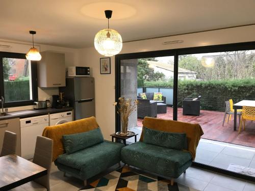 Il comprend une cuisine avec 2 chaises et une cuisine avec une terrasse. dans l'établissement Argelès sur mer appartement standing, à Argelès-sur-Mer