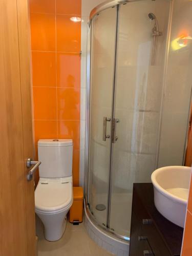 ein Badezimmer mit Dusche, Toilette und Waschbecken in der Unterkunft Aroeira Beach House in Aroeira