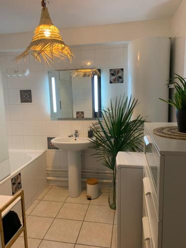 une salle de bain avec un lavabo, une baignoire et un miroir dans l'établissement Appartement Bayonne-Adour, 3 pièces, 6 personnes., à Bayonne