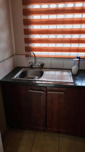 a kitchen with a sink and a window at Stone Villa in Gaborone