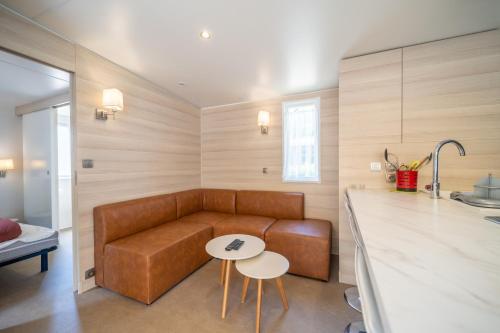 a living room with a couch and a table at Camping Les Genêts in Saint-Jean-de-Monts