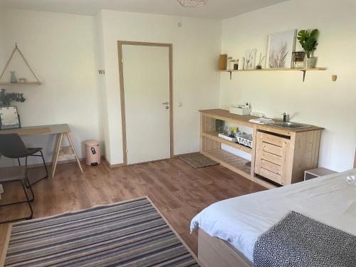 1 dormitorio con cama, escritorio y lavamanos en Cozy space with a workplace, en Võru