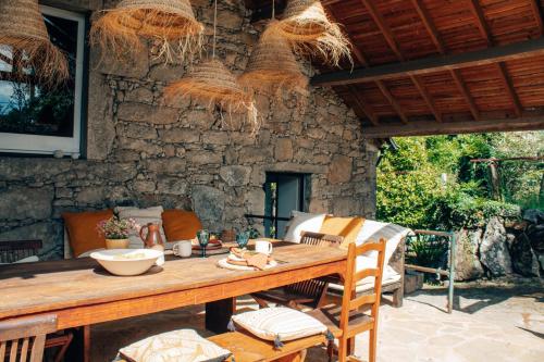 a patio with a wooden table and chairs at Just Like Home - Quinta da Cavada em Vilar de Mouros in Caminha