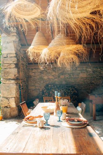 a wooden table with plates and glasses and straw at Just Like Home - Quinta da Cavada em Vilar de Mouros in Caminha
