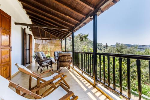 a balcony with chairs and a view of the mountains at Ourania Apartment in Skopelos Town