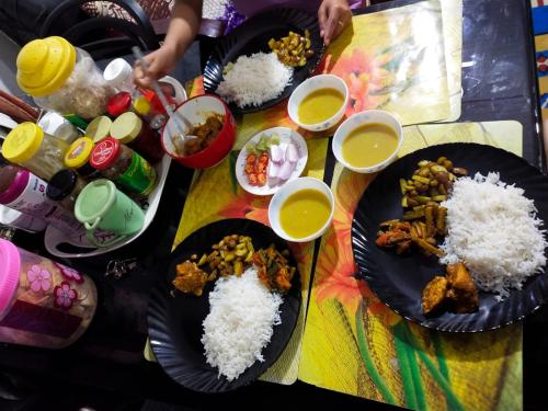 a table topped with plates of food and rice at DukeRaj Homestay in Darjeeling