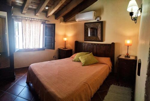 1 dormitorio con 1 cama con 2 lámparas y una ventana en B&B the lost Village el Acebuchal, en Frigiliana