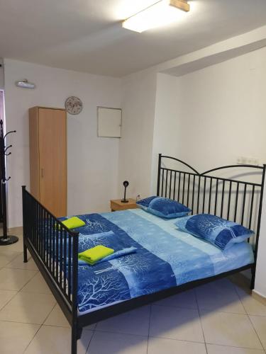 a bed with blue sheets and yellow pillows in a room at Apartment Stari Grad in Trebinje
