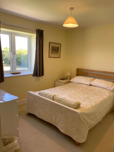 Schlafzimmer mit einem Bett und einem Fenster in der Unterkunft Folly Fields Farm B&B in Sherborne