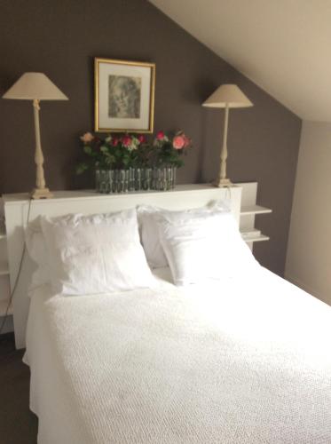 a bedroom with a white bed with two lamps on the wall at Duplex Vannes centre in Vannes