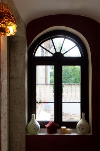 an arched window with vases on a shelf in a room at Antica Taverna del Principe in Sepino