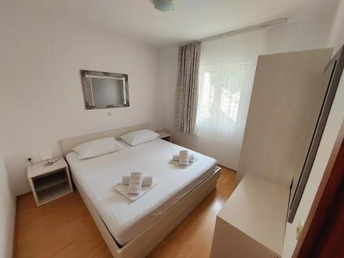 a bedroom with a white bed and a window at Apartman Patricia in Makarska