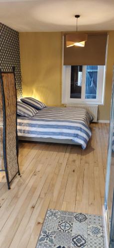 Ce lit se trouve dans un dortoir doté de parquet. dans l'établissement L'Arche d' Engel, à Courpière