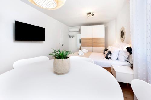 a white living room with white furniture and a tv at bed&breakfast Bohemian in Rovinj