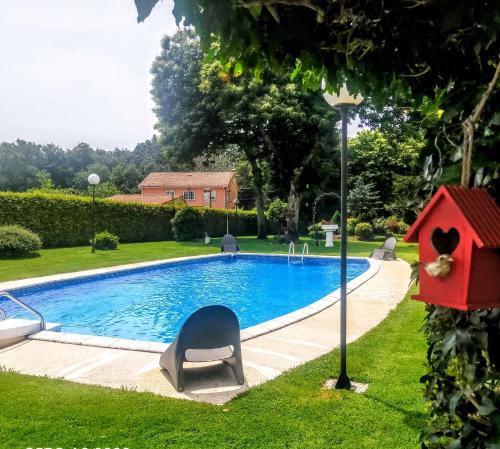 een zwembad met een vogelhuisje ernaast bij Casa Rustica Neiro in Santiago de Compostela
