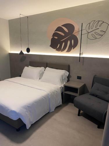 a bedroom with a large bed and a chair at Hotel Lily in Bibione
