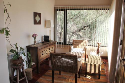 d'un salon avec une table, des chaises et une fenêtre. dans l'établissement Santa Lucia, à Tilcara
