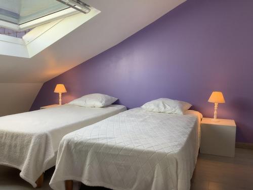 - 2 lits dans une chambre dotée d'un mur violet dans l'établissement Appartement T3 au Mont-Dore, hyper centre, proche thermes, bien équipé, max 4 pers, petit chien ok. - FR-1-608-227, à Le Mont-Dore