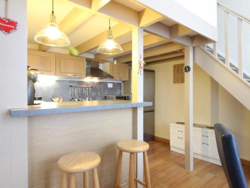 - une cuisine avec un comptoir et deux tabourets dans une pièce dans l'établissement Appartement T3 cosy avec WiFi, proche centre, Thermes & commodités, capacité 6 pers. - FR-1-608-214, à Le Mont-Dore