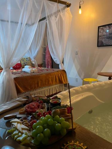 a room with a bed and a tray of food on a table at Pousada Sonho do Vale in Praia do Rosa